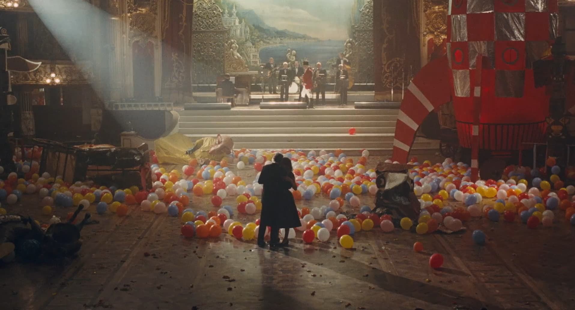A couple waltzes alone in a vast ballroom filled with balloons